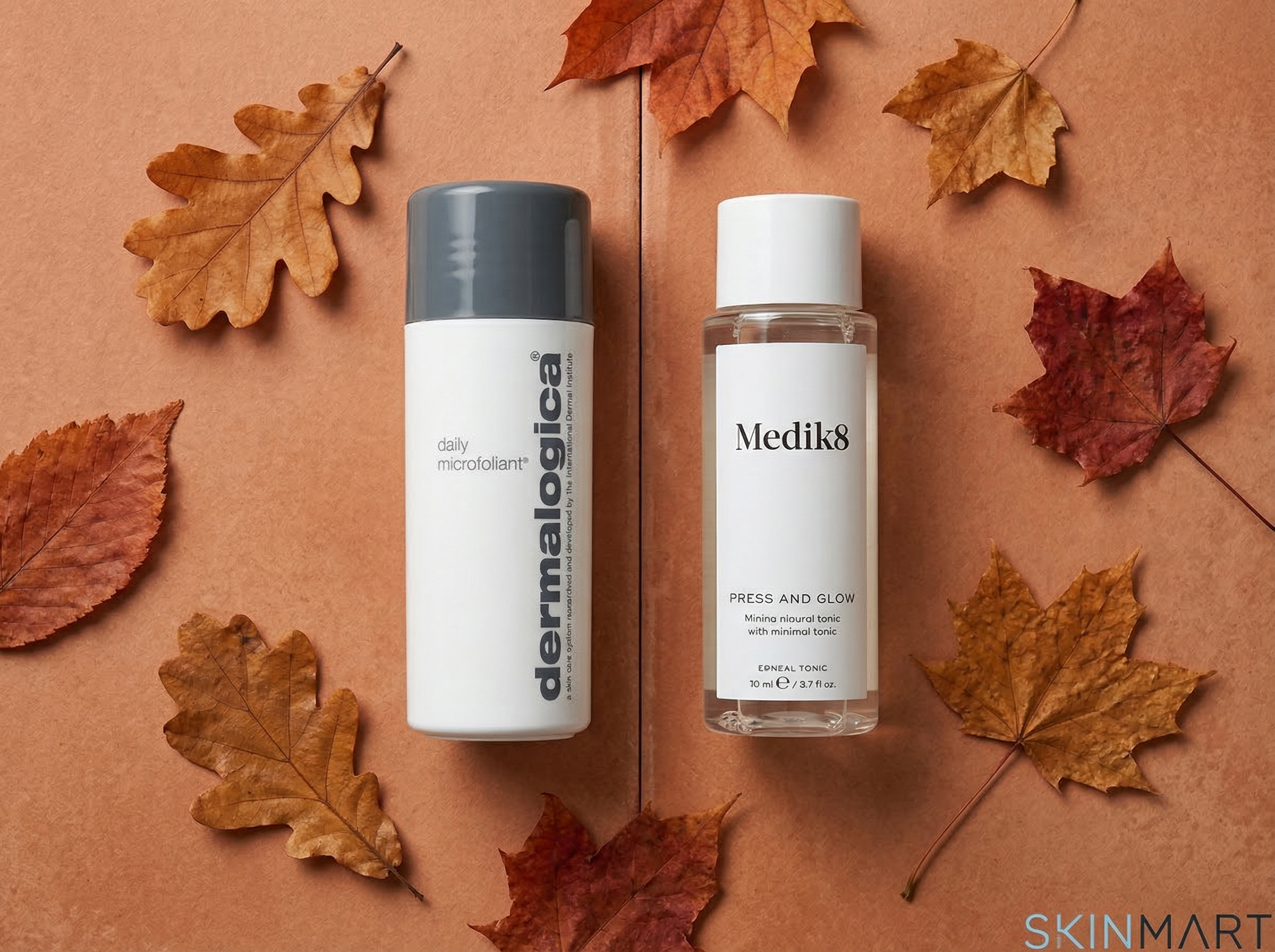 Dermalogica Daily Microfoliant and Medik8 Press and Glow side by side on a warm terracotta surface with autumn leaves, soft natural light