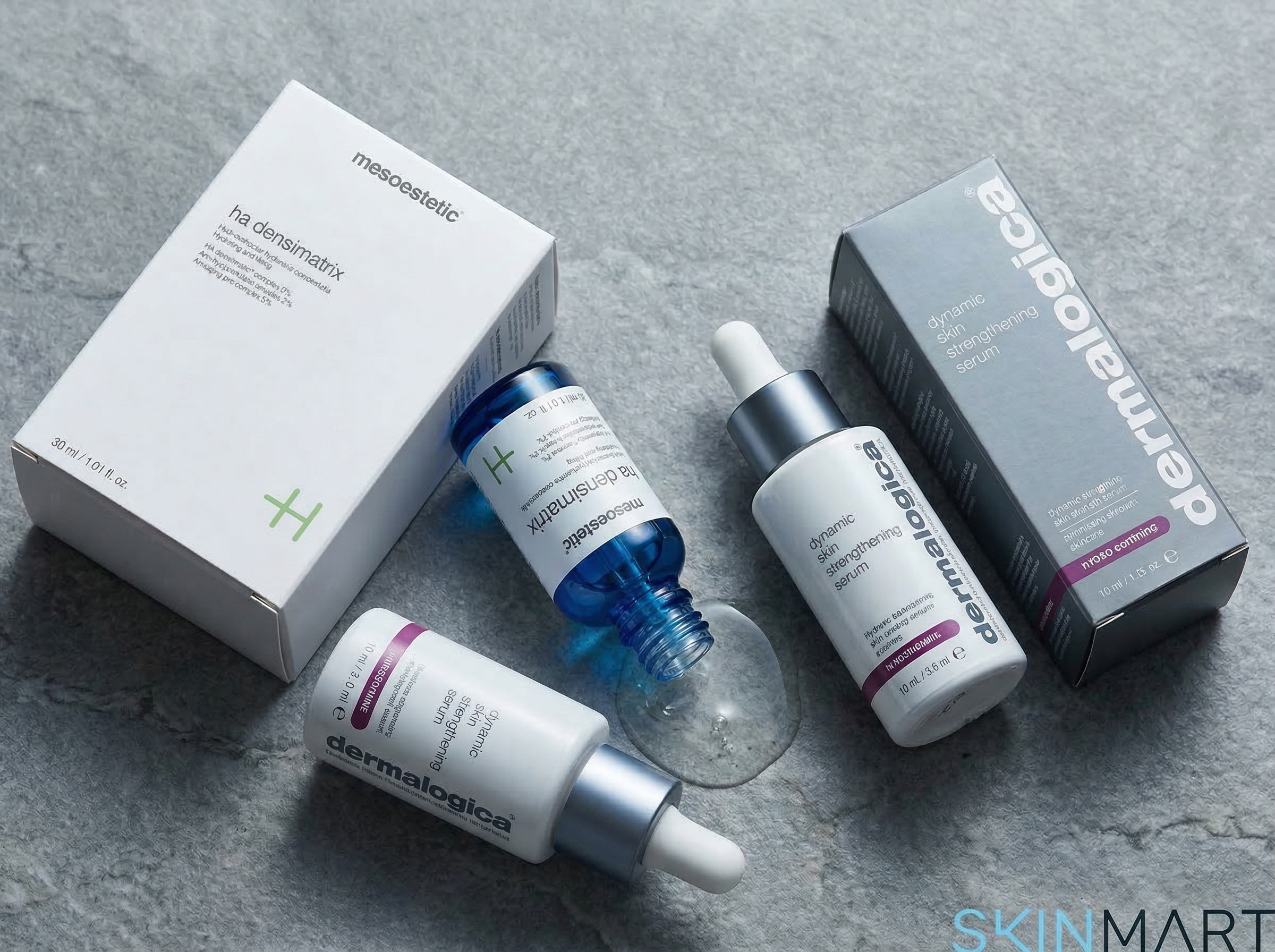 Mesoestetic ha densimatrix and Dermalogica Dynamic Skin Strengthening Serum on a grey stone surface with soft side lighting showing serum texture